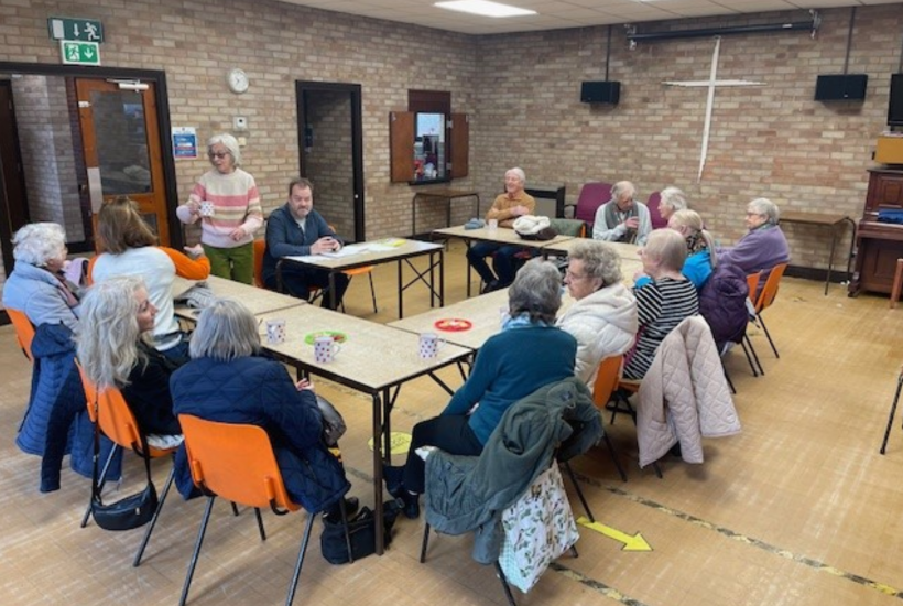 a group of people sat around a c-shaped set of tables